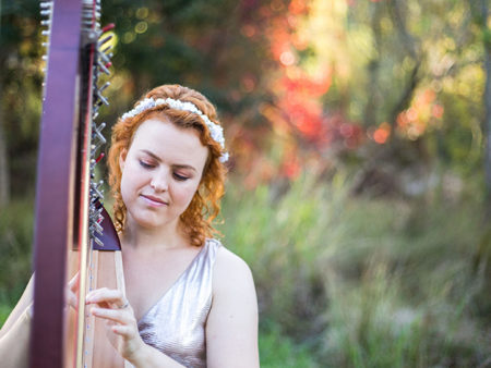 Christy-Lyn playing harp in a beautiful forest