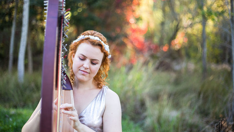 Christy-Lyn playing harp in a beautiful forest