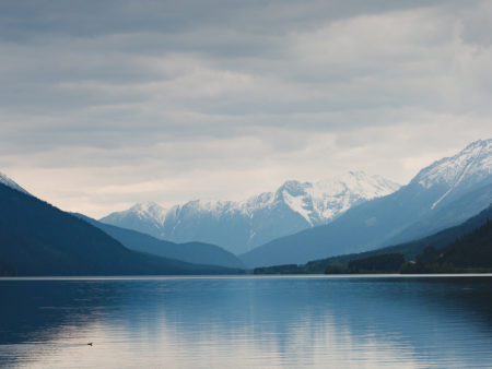 view over a lake with snowy mountains in the background