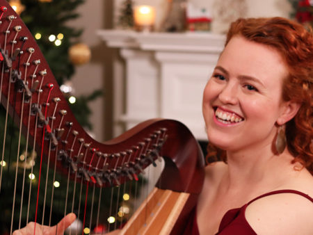 Christy-Lyn playing a lever harp in front of Christmas Tree