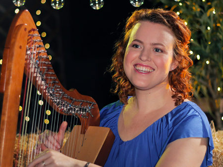 Christy-Lyn playing lever harp with Christmas tree and lights