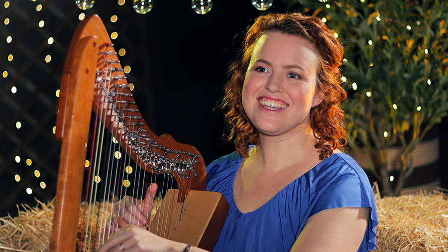 Christy-Lyn playing lever harp with Christmas tree and lights