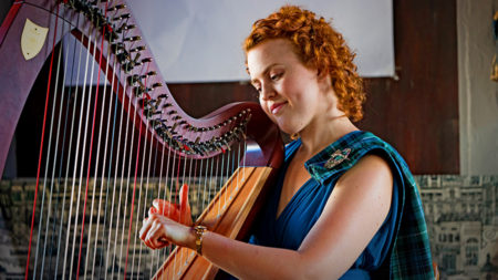 Christy-Lyn in a blue dress playing a lever harp
