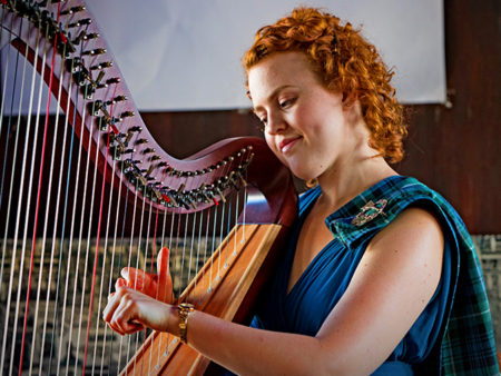 Christy-Lyn in a blue dress playing a lever harp