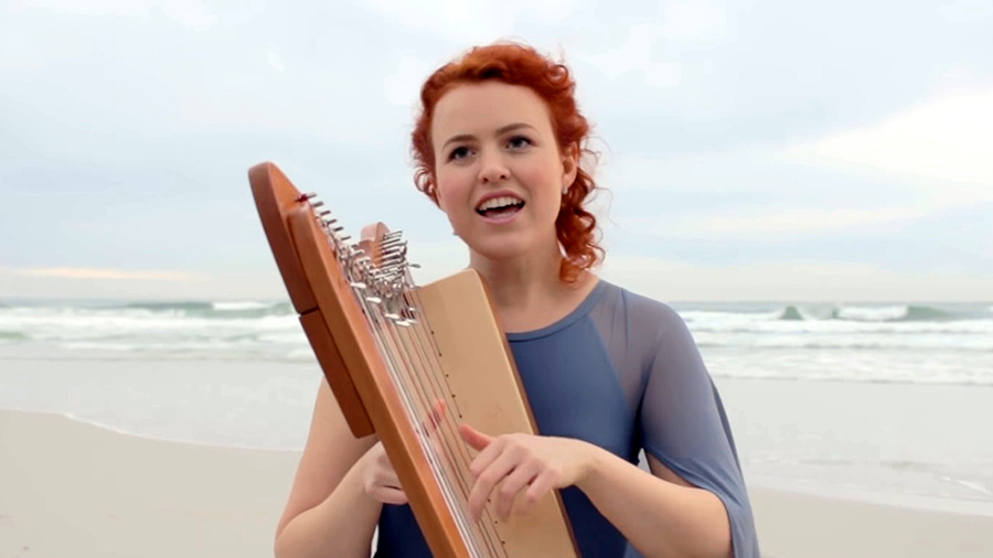 Harp player with harpsicle on the beach