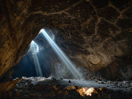light rays spilling through cave ceiling